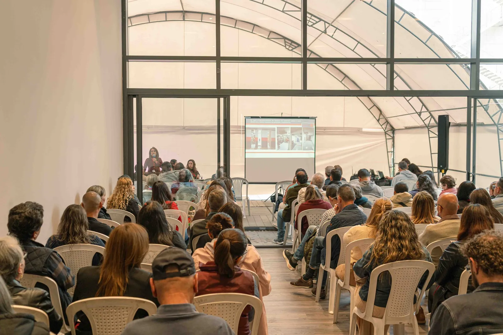 Asamblea con asistentes, pantalla y operación técnica de IDEORAPTOR S.A.S.