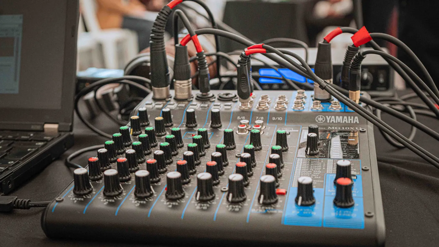 Consola Yamaha conectada a varias fuentes de audio durante la operación técnica de un evento